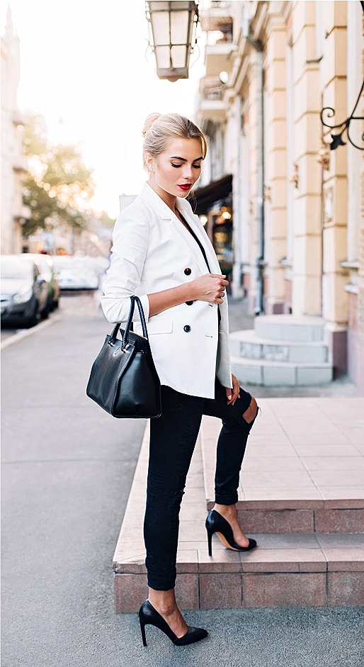 Woman in stylish outfit on city sidewalk.