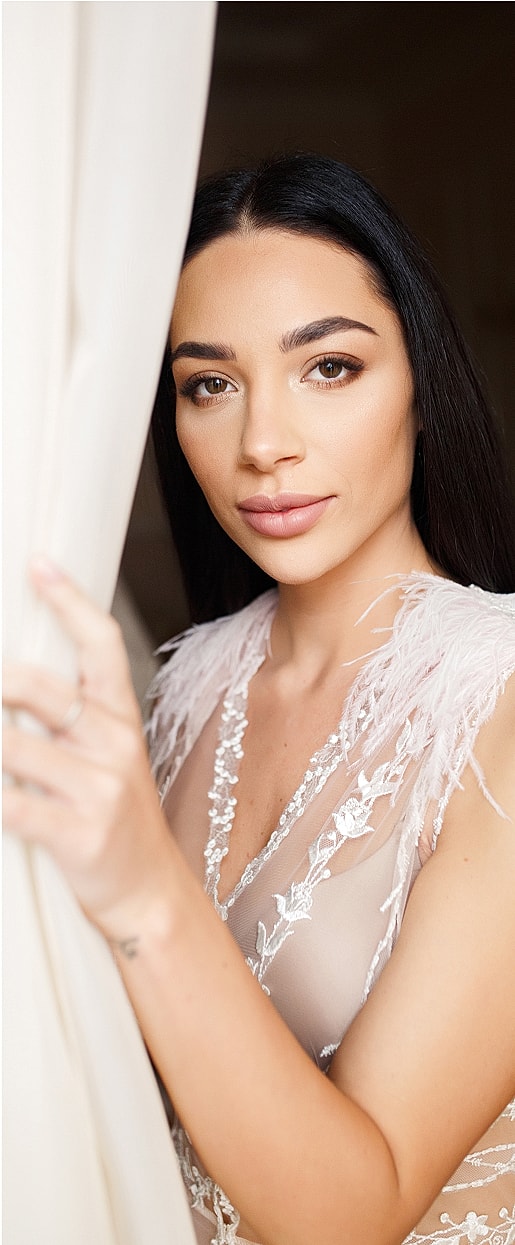 Woman in elegant dress by a window.