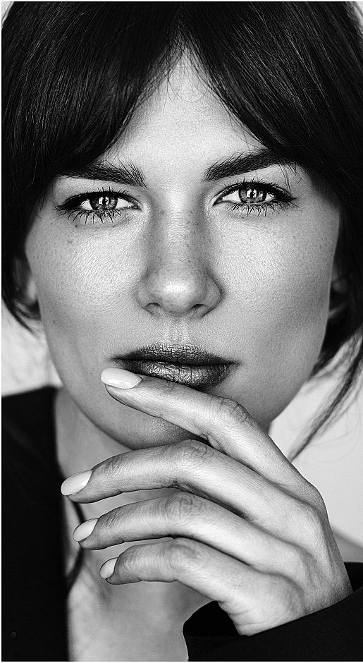 Black and white portrait of a woman gazing thoughtfully.