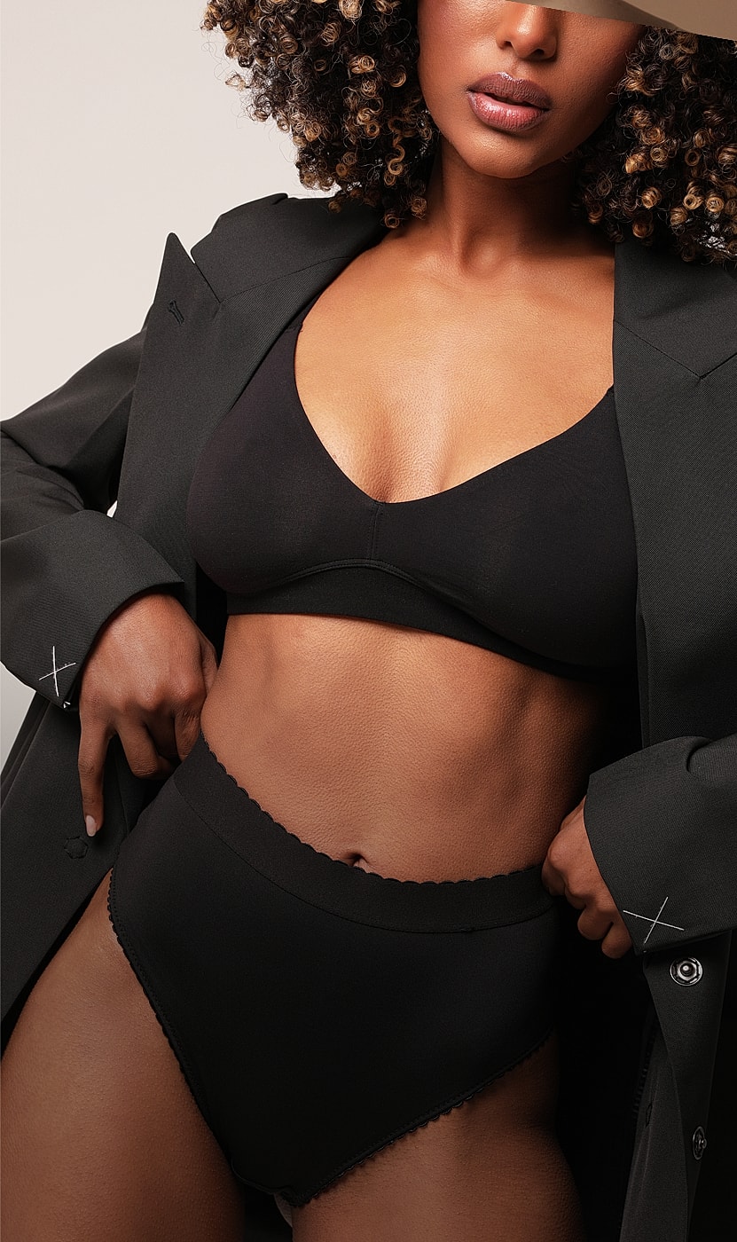 Model wearing black lingerie with oversized blazer.