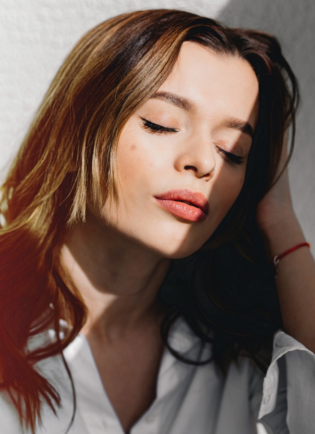 Woman with closed eyes in natural light.