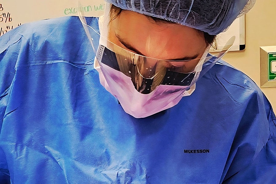 Medical professional focused on a procedure.
